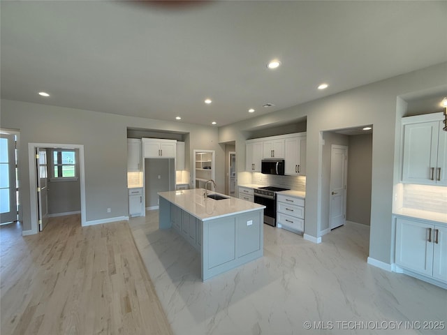 22832 E 106th Pl S, Broken Arrow, OK 74014 - kitchen with stainless steel range oven, a sink, baseboards, white cabinets, and a kitchen island with sink