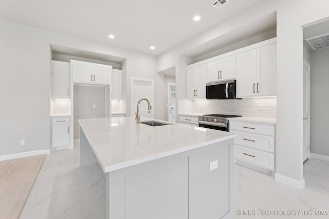 22832 E 106th Pl S, Broken Arrow, OK 74014 - kitchen with appliances with stainless steel finishes, decorative backsplash, an island with sink, light marble finish flooring, and white cabinets