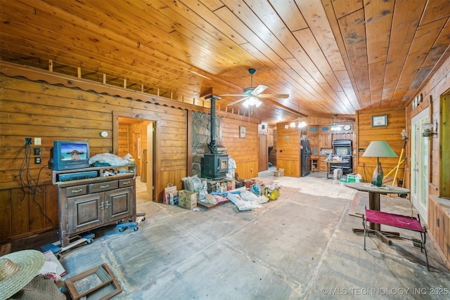 21745 E 660th Rd, Tahlequah, OK 74464 - living area featuring a wood stove, wood ceiling, ceiling fan, and wooden walls