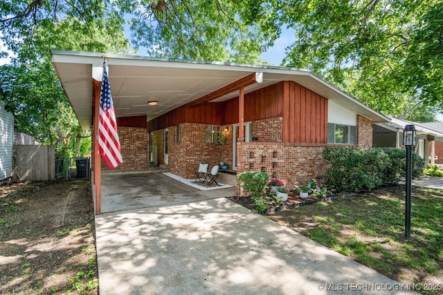 953 E 37th St, Tulsa, OK 74105 - mid-century inspired home with concrete driveway, brick siding, and an attached carport