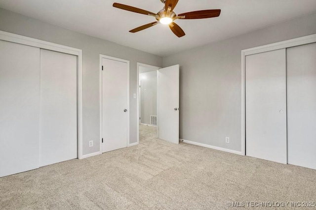 953 E 37th St, Tulsa, OK 74105 - unfurnished bedroom featuring two closets, carpet flooring, baseboards, and a ceiling fan
