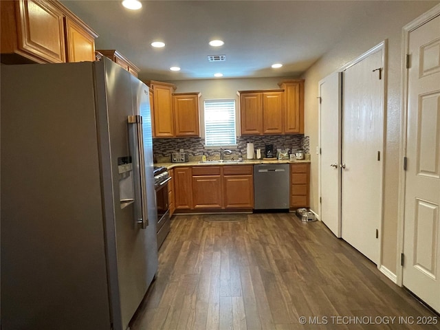 141 W Fairlane Pl, Sapulpa, OK 74066 - kitchen with appliances with stainless steel finishes, a sink, dark wood-type flooring, tasteful backsplash, and light countertops