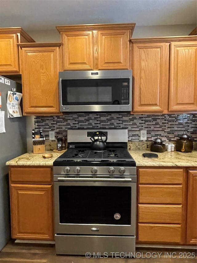 141 W Fairlane Pl, Sapulpa, OK 74066 - kitchen with stainless steel appliances, decorative backsplash, and light stone counters