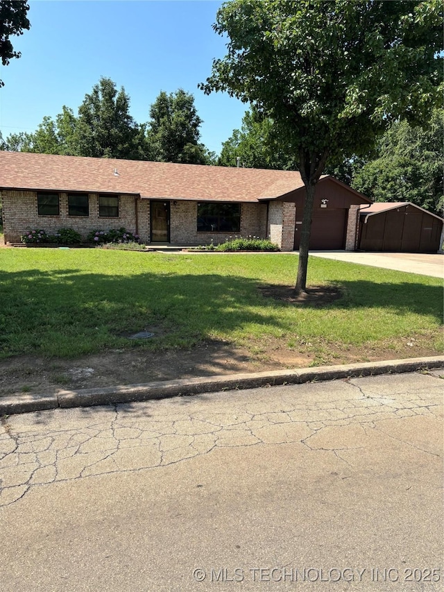 1339 E 9th St, Cushing, OK 74023 - ranch-style home featuring a garage, a front lawn, concrete driveway, and brick siding