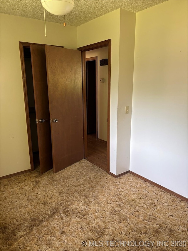 1339 E 9th St, Cushing, OK 74023 - spare room with carpet flooring, a textured ceiling, and baseboards