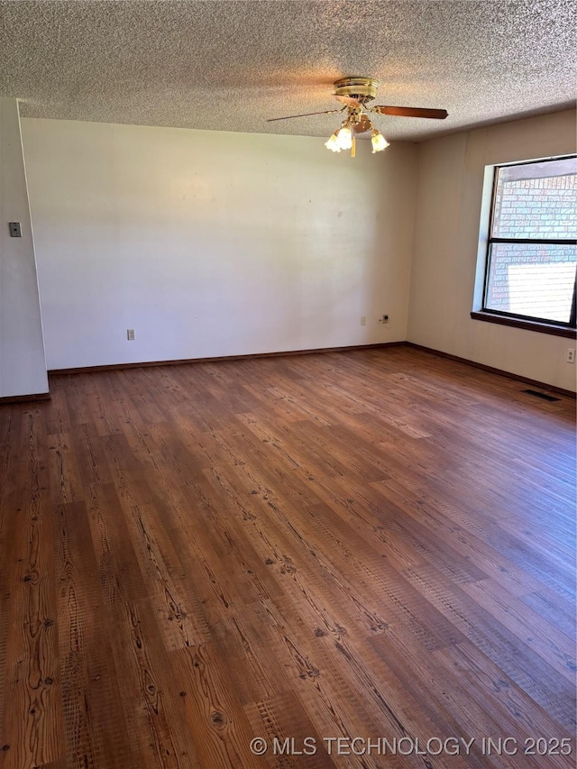 1339 E 9th St, Cushing, OK 74023 - unfurnished room with dark wood-style flooring, ceiling fan, baseboards, and a textured ceiling