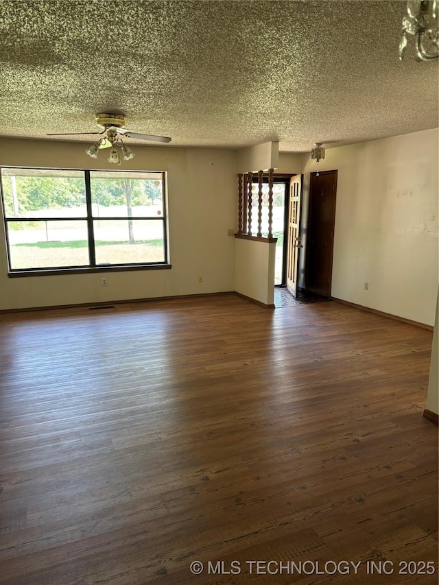1339 E 9th St, Cushing, OK 74023 - empty room with a textured ceiling, a ceiling fan, dark wood-style floors, and baseboards
