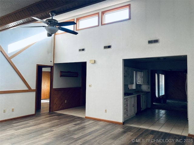 3814 E Dripping Springs Rd, Cushing, OK 74023 - unfurnished living room with a ceiling fan, baseboards, wood finished floors, and a high ceiling