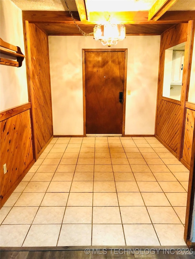 3814 E Dripping Springs Rd, Cushing, OK 74023 - hallway featuring wood walls, a chandelier, light tile patterned floors, and a wainscoted wall