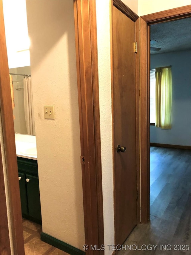 3814 E Dripping Springs Rd, Cushing, OK 74023 - hallway featuring a textured wall and wood finished floors