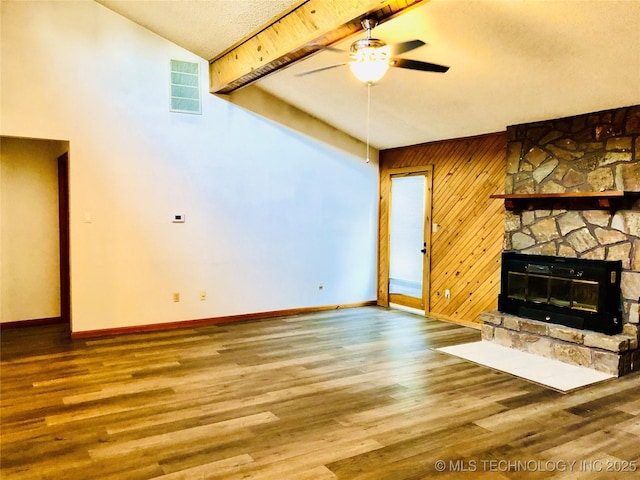 3814 E Dripping Springs Rd, Cushing, OK 74023 - unfurnished living room featuring ceiling fan, baseboards, wood finished floors, a fireplace, and wood walls