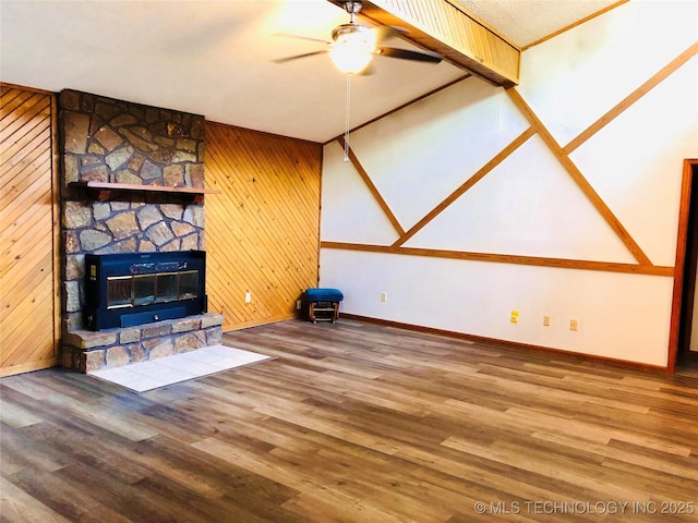 3814 E Dripping Springs Rd, Cushing, OK 74023 - unfurnished living room featuring a ceiling fan, baseboards, wood finished floors, a fireplace, and wooden walls