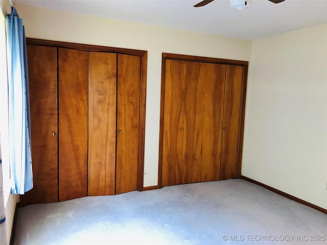 3814 E Dripping Springs Rd, Cushing, OK 74023 - unfurnished bedroom with light carpet, two closets, baseboards, and ceiling fan