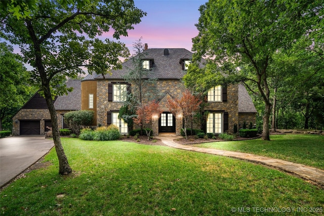 10144 N Dover Pl, Owasso, OK 74055 - tudor house featuring french doors, stone siding, driveway, and a chimney