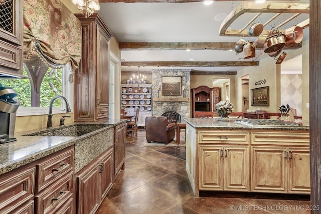 10144 N Dover Pl, Owasso, OK 74055 - kitchen featuring a fireplace, open floor plan, stone countertops, beamed ceiling, and stainless steel gas stovetop