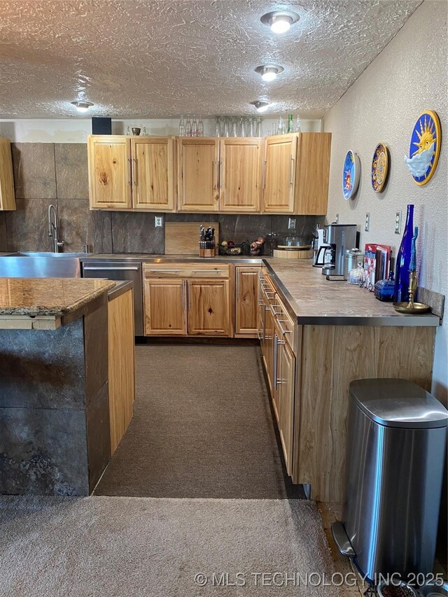 11477 State Highway 70, Madill, OK 73446 - kitchen with dark carpet, a textured ceiling, a textured wall, stainless steel dishwasher, and tasteful backsplash