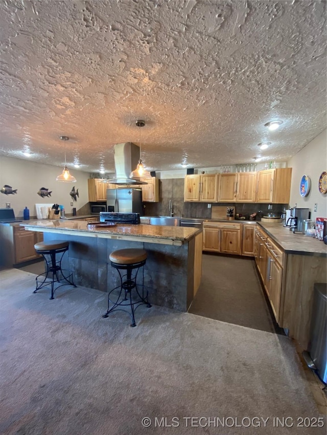 11477 State Highway 70, Madill, OK 73446 - kitchen with island exhaust hood, dark carpet, a textured ceiling, a breakfast bar, and a spacious island