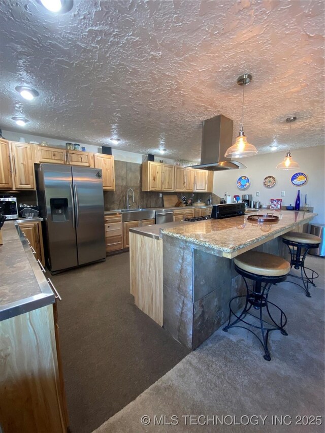11477 State Highway 70, Madill, OK 73446 - kitchen featuring stainless steel appliances, range hood, a breakfast bar area, carpet, and light brown cabinetry