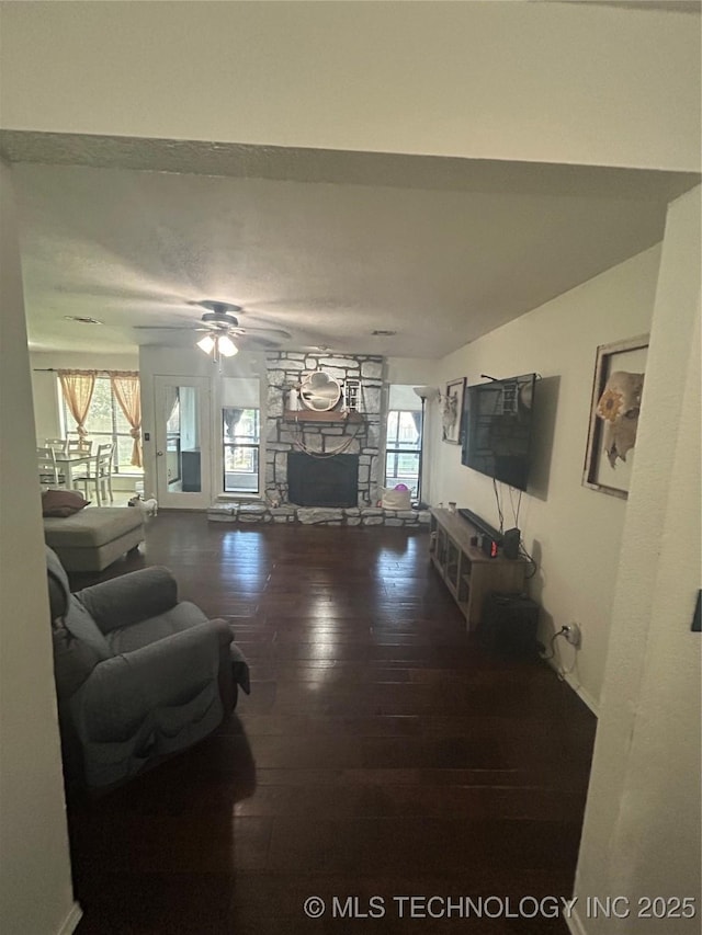 4509 W Toledo St, Broken Arrow, OK 74012 - living area featuring hardwood / wood-style floors, a stone fireplace, a ceiling fan, and healthy amount of natural light