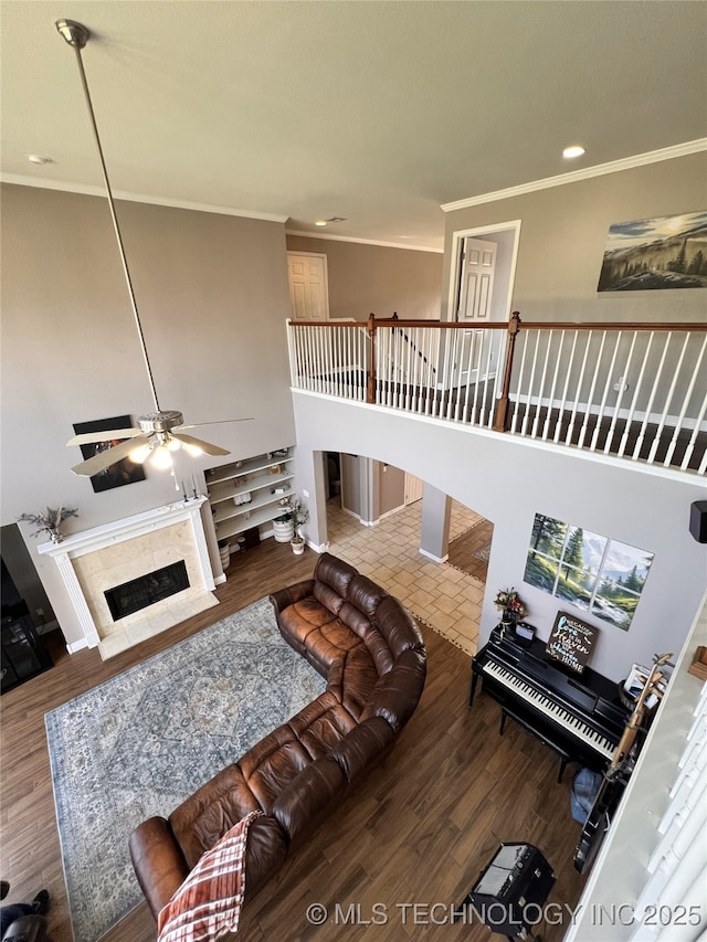 1816 W Sandusky St, Broken Arrow, OK 74012 - living area featuring ornamental molding, a high ceiling, ceiling fan, wood finished floors, and a premium fireplace