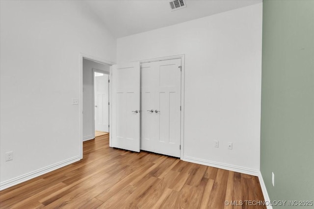 153 Founders Ln, Durant, OK 74701 - unfurnished bedroom with light wood finished floors, baseboards, a closet, and lofted ceiling