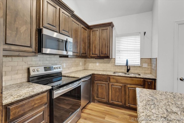153 Founders Ln, Durant, OK 74701 - kitchen featuring stainless steel appliances, a sink, tasteful backsplash, light stone countertops, and light wood-style floors