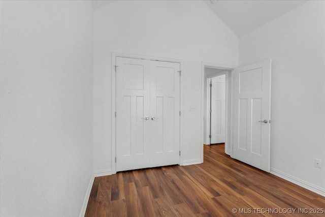 153 Founders Ln, Durant, OK 74701 - unfurnished bedroom featuring baseboards, dark wood-style floors, high vaulted ceiling, and a closet