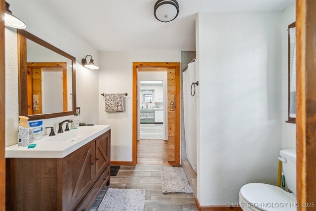 11029 N 3670th Rd, Okemah, OK 74884 - bathroom with vanity, toilet, wood finished floors, baseboards, and a shower with curtain