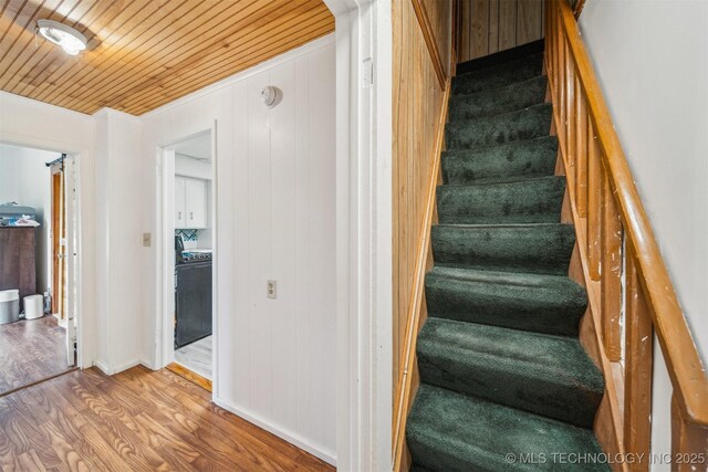 11029 N 3670th Rd, Okemah, OK 74884 - staircase featuring wood finished floors, washer / clothes dryer, wood ceiling, baseboards, and wood walls