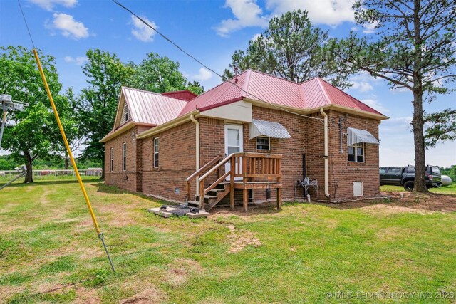 11029 N 3670th Rd, Okemah, OK 74884 - back of house with brick siding, a yard, and metal roof