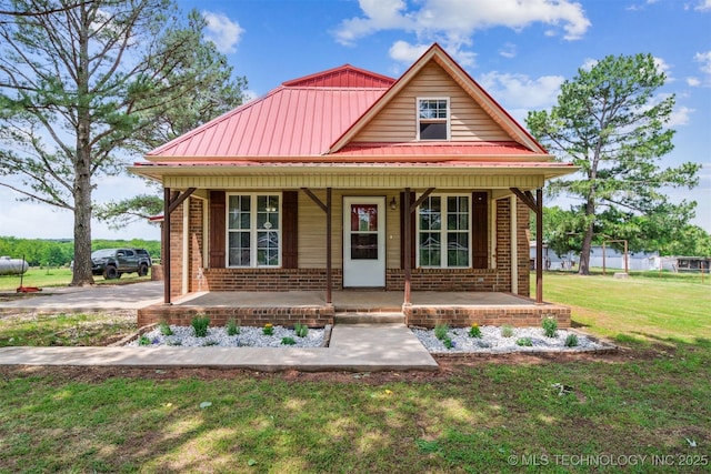 11029 N 3670th Rd, Okemah, OK 74884 - bungalow with covered porch, brick siding, a front yard, and metal roof