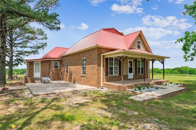 11029 N 3670th Rd, Okemah, OK 74884 - rear view of property featuring brick siding, metal roof, covered porch, and a patio