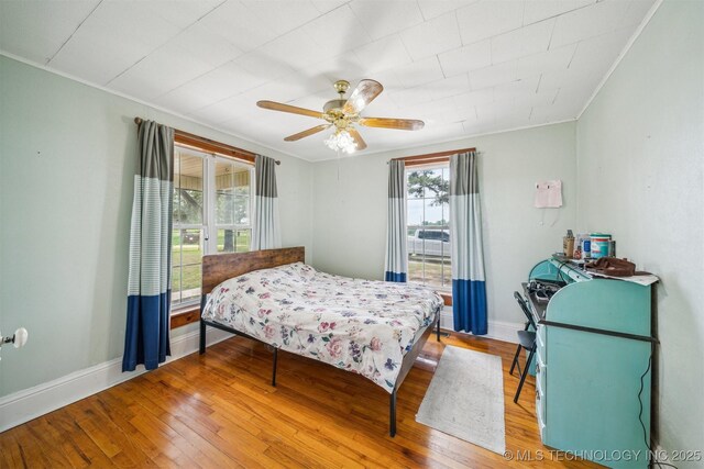 11029 N 3670th Rd, Okemah, OK 74884 - bedroom featuring wood finished floors, ornamental molding, a ceiling fan, and baseboards
