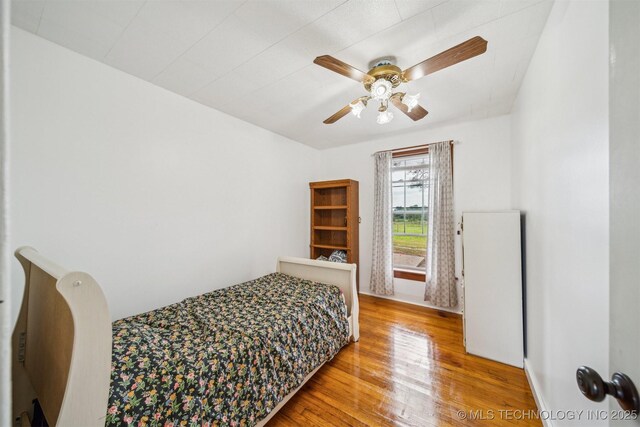 11029 N 3670th Rd, Okemah, OK 74884 - bedroom featuring wood finished floors, ceiling fan, and baseboards