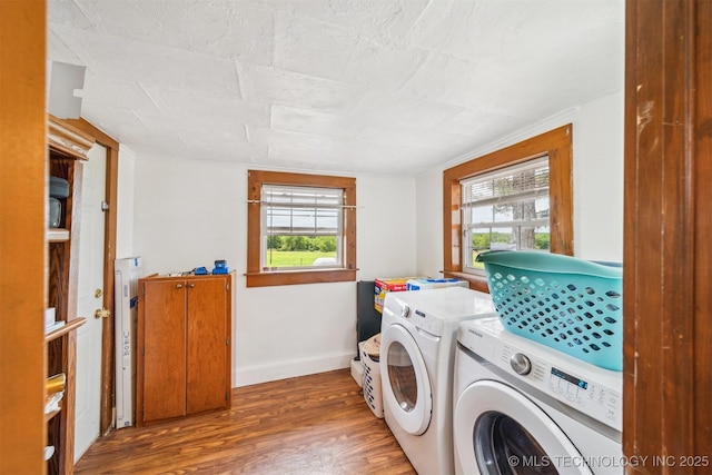 11029 N 3670th Rd, Okemah, OK 74884 - washroom featuring wood finished floors, washing machine and clothes dryer, healthy amount of natural light, and baseboards