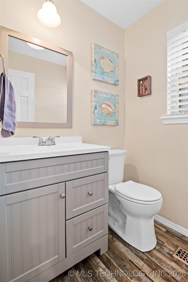 8313 Shadowood Ave, Broken Arrow, OK 74011 - bathroom with wood finished floors, vanity, toilet, and baseboards