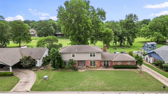 8313 Shadowood Ave, Broken Arrow, OK 74011 - view of front facade with brick siding, driveway, a front yard, and view of wooded area