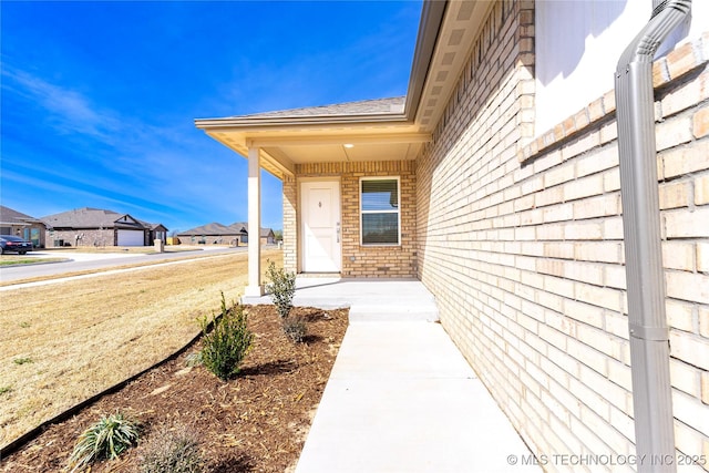 304 S 25th St, Collinsville, OK 74021 - doorway to property with brick siding, a residential view, and roof with shingles