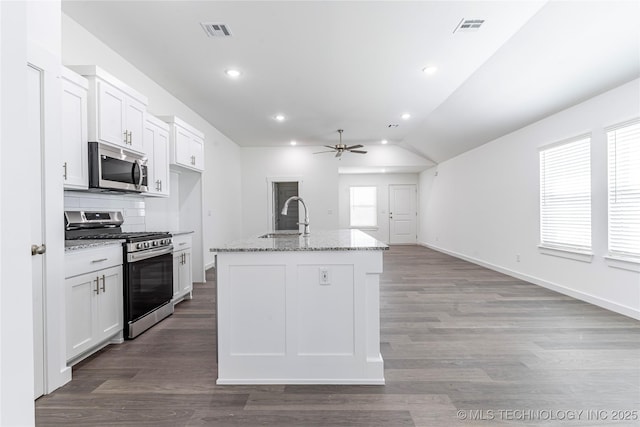 304 S 25th St, Collinsville, OK 74021 - kitchen with stainless steel appliances, a sink, a ceiling fan, vaulted ceiling, and white cabinets