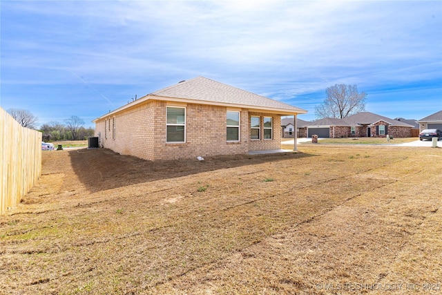 304 S 25th St, Collinsville, OK 74021 - back of property with brick siding, central air condition unit, and roof with shingles