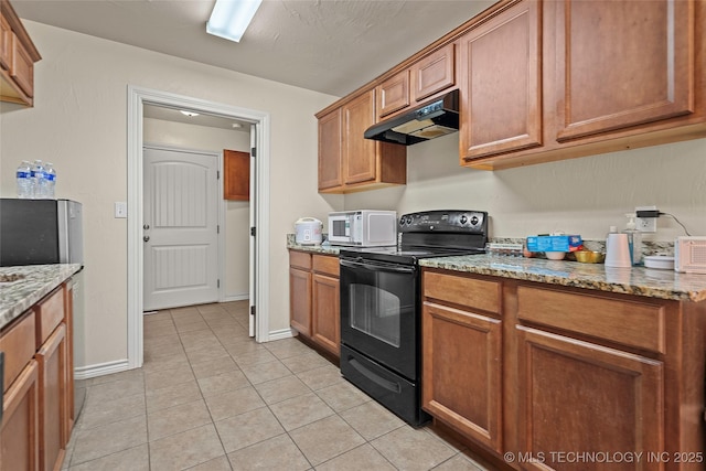 1204 Gantt, Marietta, OK 73448 - kitchen with black range with electric cooktop, under cabinet range hood, light tile patterned floors, and brown cabinetry
