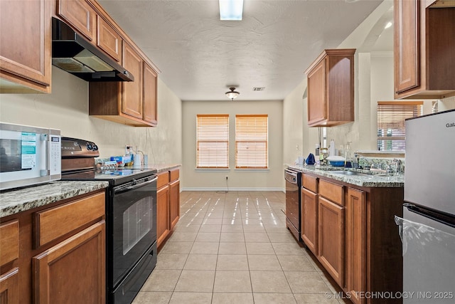 1204 Gantt, Marietta, OK 73448 - kitchen with black appliances, exhaust hood, a sink, baseboards, and brown cabinetry