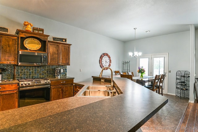 15610 E 91st St, Owasso, OK 74055 - kitchen with stainless steel appliances, decorative backsplash, a chandelier, dark countertops, and hanging light fixtures