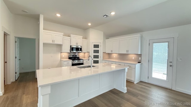 14984 S Oak St, Glenpool, OK 74033 - kitchen with appliances with stainless steel finishes, a sink, white cabinets, dark wood finished floors, and vaulted ceiling