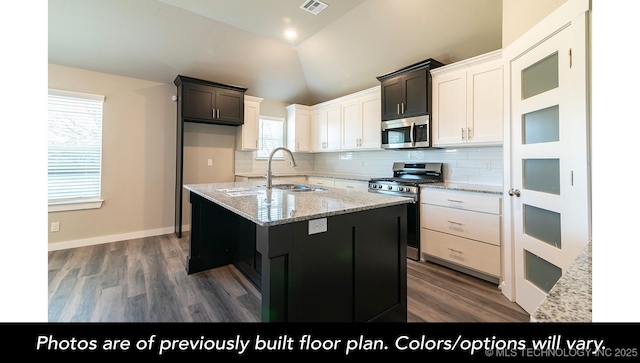 1411 E 149th Pl S, Glenpool, OK 74033 - kitchen with appliances with stainless steel finishes, a sink, wood finished floors, decorative backsplash, and lofted ceiling