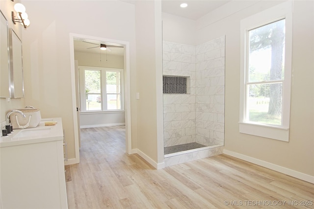 611 N State St, Wagoner, OK 74467 - bathroom with tiled shower, double vanity, wood finished floors, and baseboards
