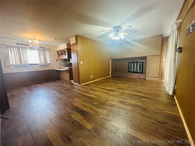 3405 S 85th E Ave, Tulsa, OK 74145 - unfurnished living room with a brick fireplace, a chandelier, a ceiling fan, dark wood-style floors, and baseboards