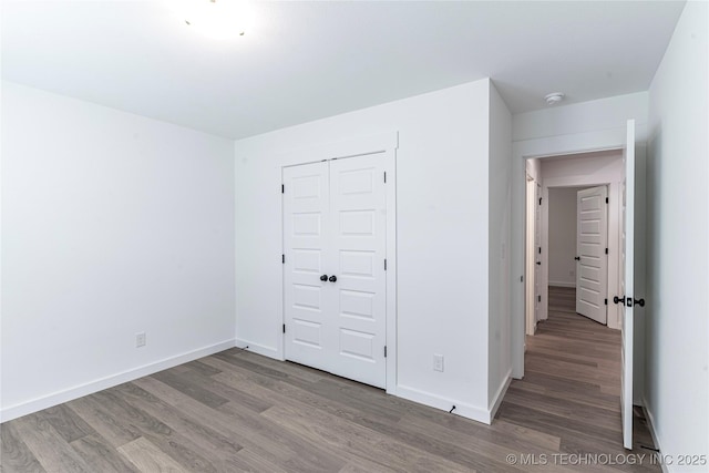 27790 E 109th Pl S, Coweta, OK 74429 - unfurnished bedroom featuring wood finished floors, a closet, and baseboards