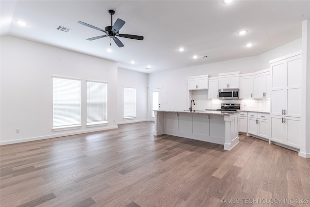 27790 E 109th Pl S, Coweta, OK 74429 - kitchen featuring appliances with stainless steel finishes, a sink, open floor plan, tasteful backsplash, and recessed lighting