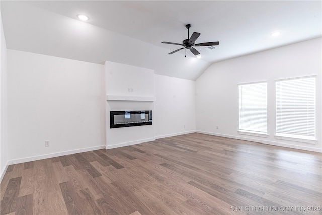 27790 E 109th Pl S, Coweta, OK 74429 - unfurnished living room featuring vaulted ceiling, light wood-style flooring, a glass covered fireplace, ceiling fan, and baseboards